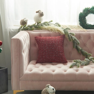 Red knit Christmas pillow cover with rustic wool texture on a pink velvet sofa setup