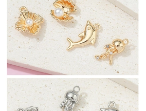 Detalle macro de colgantes marinos de aleación con concha y delfín para joyería DIY