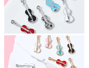 Macro shot of colorful enamel violin pendants with gold and silver plated metal bases