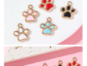 Close-up of colorful glitter paw pendants in five colors with golden metallic edges