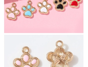 Detailed macro view showing colorful glitter paw pendants with golden metal backing details