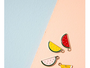 Close-up of summer fruit charms including watermelon and lemon for DIY jewelry making