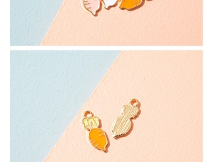Detail of carrot charms showing the front enamel finish and back gold textured metal