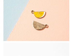 Macro view of lemon slice alloy pendants showing front enamel detail and golden metal back