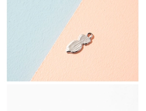 Detailed close-up of a silver metal gourd pendant with a textured hammered finish surface