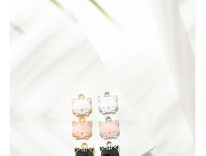 Close-up of cute cartoon cat enamel charms in white, pink and black for DIY jewelry making
