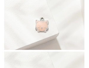Macro shot of light pink cartoon cat charm with silver alloy edges and top hanging loop