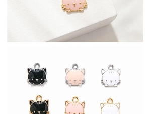Detailed close-up of cute cartoon cat alloy charms in black, pink, and white enamel