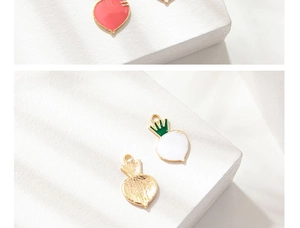 Detailed close-up of colorful carrot alloy charms with glossy enamel finish and gold plating