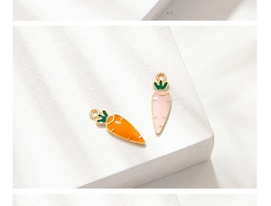 Close-up of orange and pink carrot charms with gold alloy edges and enamel finish