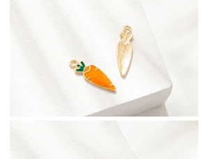Detail of double-sided enamel carrot charm with orange finish and gold metal back