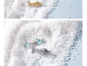 Macro detail of three-style alloy fishbone pendants in gold and silver for jewelry making