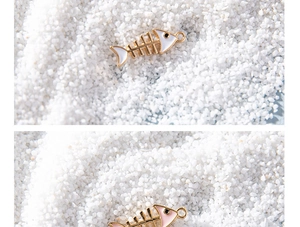 Macro shot of white and pink fishbone alloy pendants with gold-plated edges and enamel finish