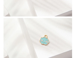 Detailansicht eines lächelnden blauen Wolkenanhängers aus Emaille für DIY-Schmuck