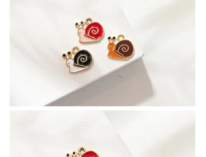 Macro view of colorful enamel snail charms in red, brown, and black for DIY jewelry making