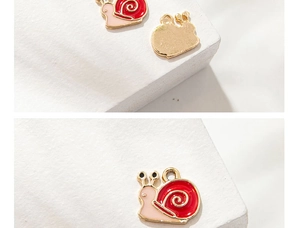Macro shot showing front enamel details and golden metal back of cartoon snail charm