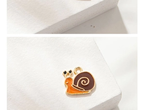 Detailed macro view of a cute orange snail alloy pendant with golden edges and charm ring