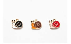 Detailed view of colorful enamel snail charms for DIY jewelry making in three colors