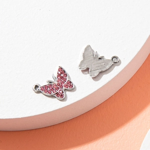 Pink rhinestone butterfly pendant with silver plating and metal hanging loop for jewelry