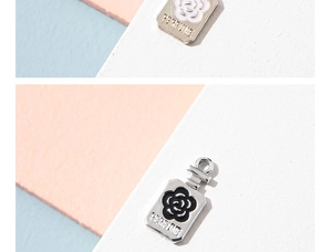 Detail of camellia perfume bottle charms in black and white enamel alloy for DIY jewelry
