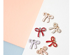 Close-up of colorful alloy bow pendants with gold edges for DIY jewelry making
