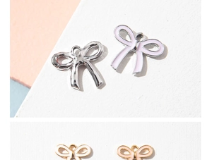 Macro detail of alloy bow charms with colorful enamel finish for DIY jewelry making