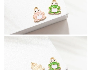 Detail of pink and green enamel frog charms with gold metal backing for DIY jewelry making