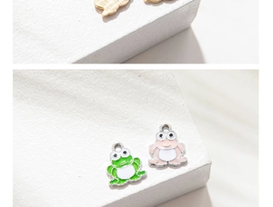 Detail of green and pink enamel frog charms and golden butterfly pendants for DIY jewelry