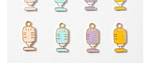 Macro detail of colorful microphone enamel charms with gold and silver hooks for DIY jewelry