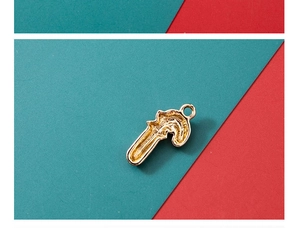 Macro shot of gold-plated candy cane charm with textured back for Christmas jewelry