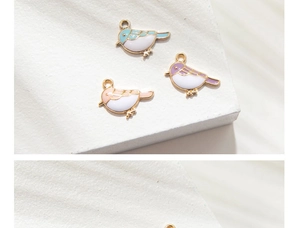 Macro shot of colorful bird enamel charms in blue, purple, and pink for DIY jewelry