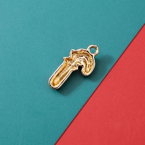 Golden candy cane pendant accessory with festive red and green background