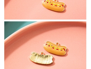Macro-detail van de hotdog-bedel met kleurrijk emaille en gouden metalen textuur achterop