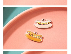 Detail van cartoon hotdog emaille bedeltjes in oranje en roze voor DIY sieraden maken