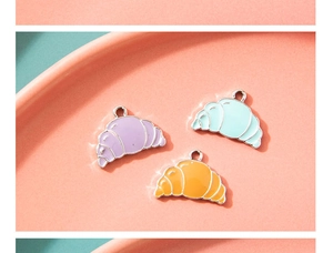 Detail view of colorful croissant charms in purple, blue, and orange for DIY jewelry making