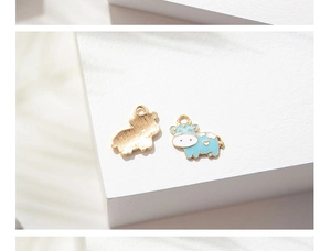 Dettaglio fronte e retro del ciondolo a forma di mucca con smalto blu e finitura oro