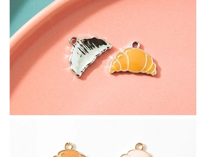 Macro detail of alloy croissant charms with colorful enamel finish and polished back