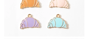 Close-up of colorful enamel croissant charms in gold-tone alloy for DIY jewelry