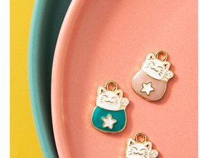 Détail de pendentifs chat porte-bonheur en émail rose et bleu pour bijoux DIY