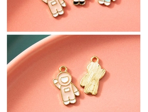 Detailed close-up of pink and white astronaut charms with gold alloy finish for DIY jewelry