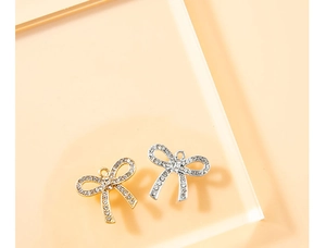 Vista macro de colgantes de lazo plateados y dorados con diamantes de imitación para DIY