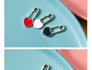 Detail of colorful enamel heart paperclip charms in red, white and black alloy metal