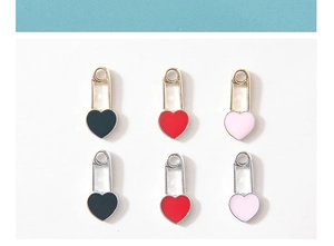 Macro shot of colorful enamel heart paperclip pendants in gold and silver plating