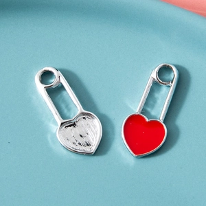 Silver heart safety pin pendant with vibrant red enamel inlay on light blue surface
