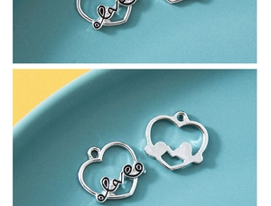 Makroaufnahme von silbernem Herzanhänger mit Love-Gravur für DIY-Schmuckherstellung