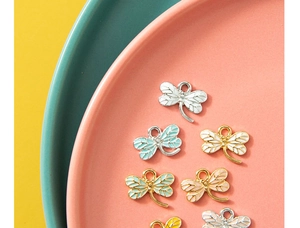 Macro detail of enamel dragonfly charms for DIY jewelry in various pastel colors