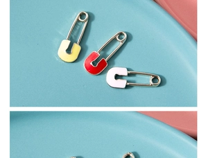 Gros plan de pendentifs trombones rouges, jaunes et blancs sur une assiette bleue
