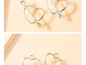Dettaglio macro di ciondoli a cuore e freccia per gioielli DIY in argento e oro