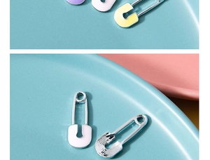 Vue macro de pendentifs trombones argentés avec détails en émail coloré aux tons pastel