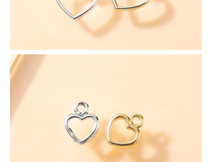 Dettaglio di ciondoli a cuore vuoto in finitura oro e argento con anelli di sospensione